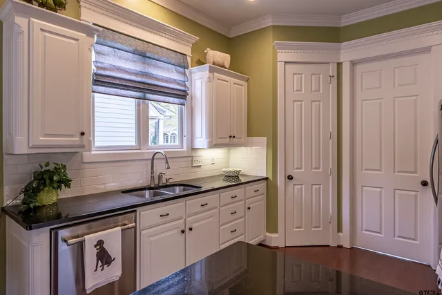 a kitchen with granite countertop a sink and cabinets
