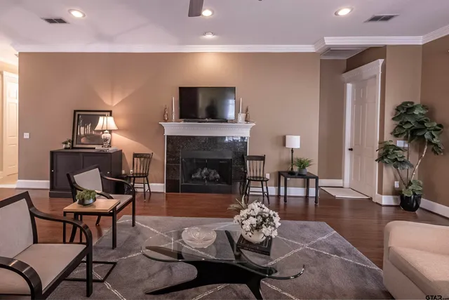 a living room with furniture a fireplace and a flat screen tv