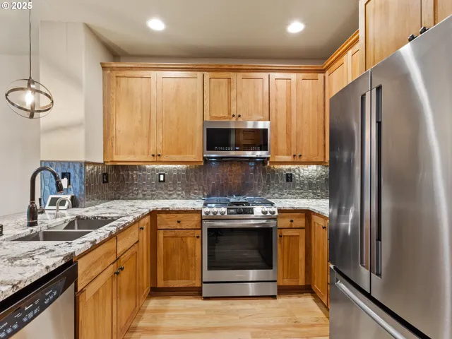 a kitchen with stainless steel appliances a refrigerator sink and microwave