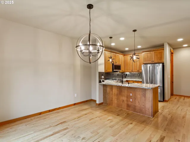 a view of a kitchen with kitchen island stainless steel appliances and wooden floor