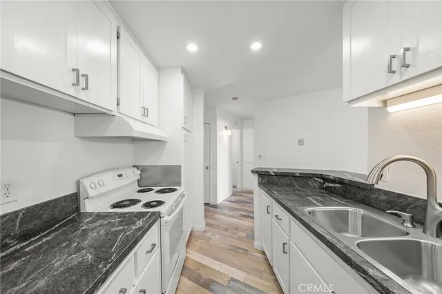 a kitchen with granite countertop a sink and cabinets