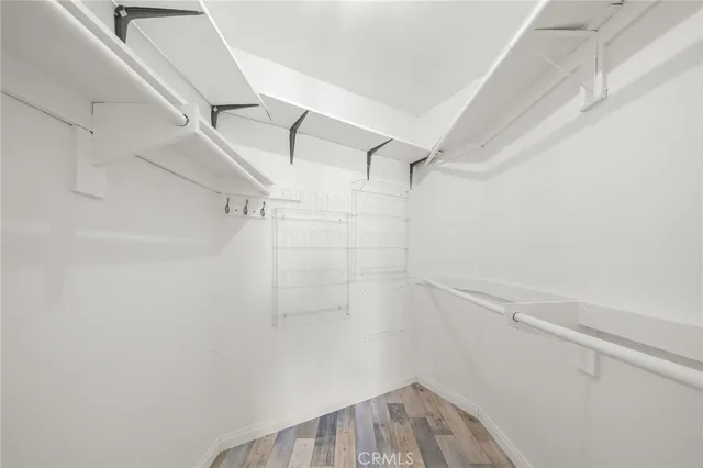 a view of a big room with wooden floor and windows