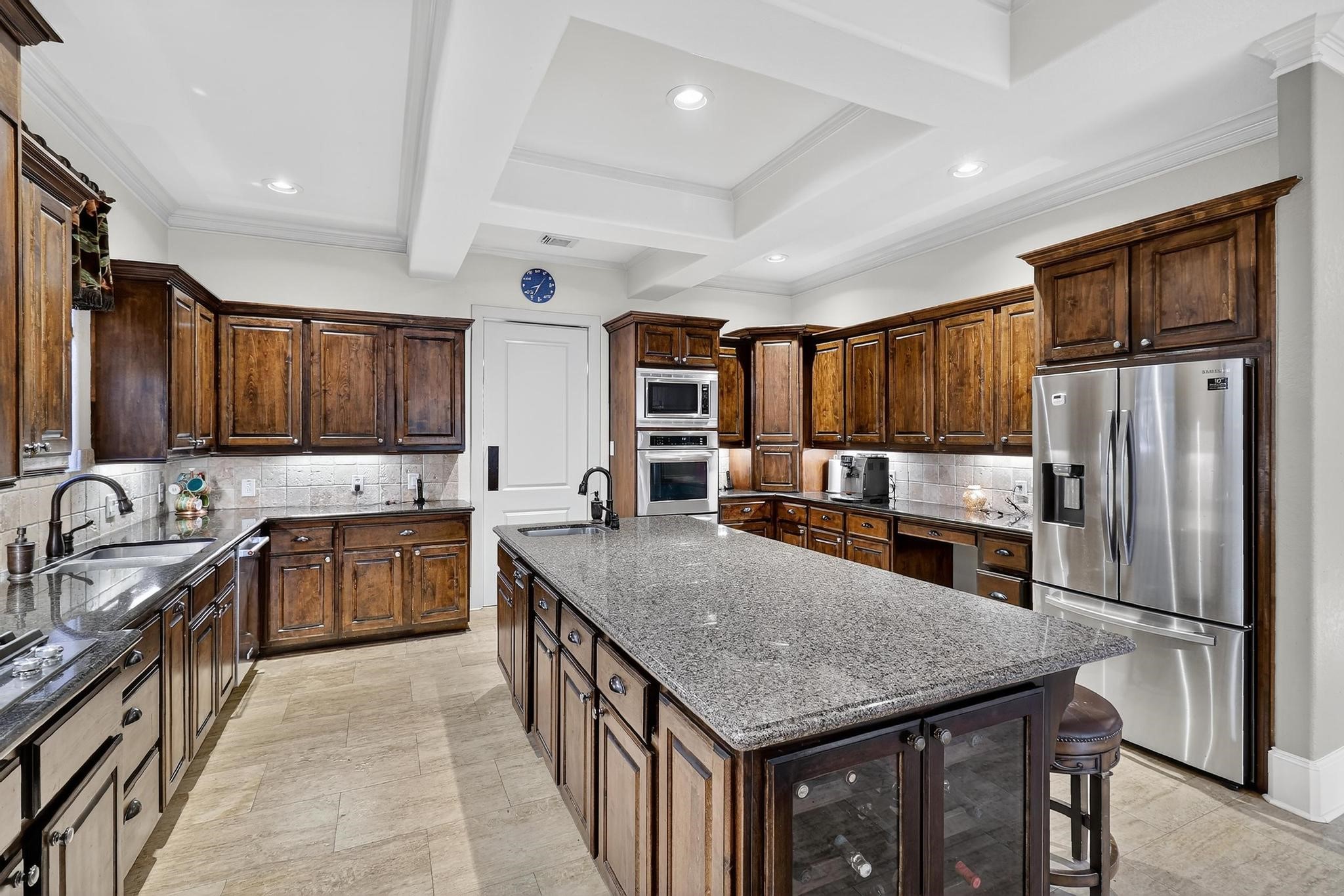 420 Whispering Meadow Magnolia, TX 77355 - Photo 16 of 44 a kitchen with stainless steel appliances granite countertop a kitchen island hardwood floor sink stove refrigerator and cabinets