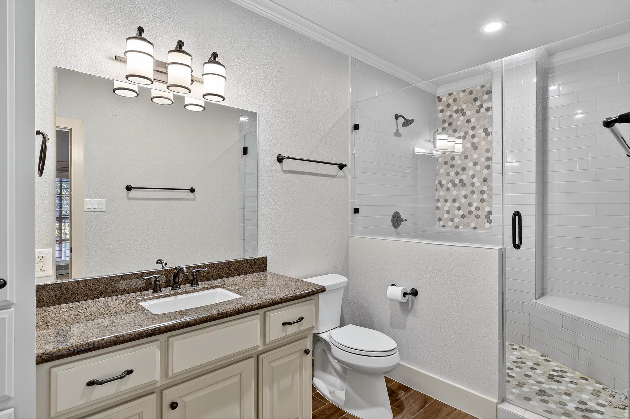 420 Whispering Meadow Magnolia, TX 77355 - Photo 21 of 44 a bathroom with a granite countertop sink a toilet a mirror a vanity and shower