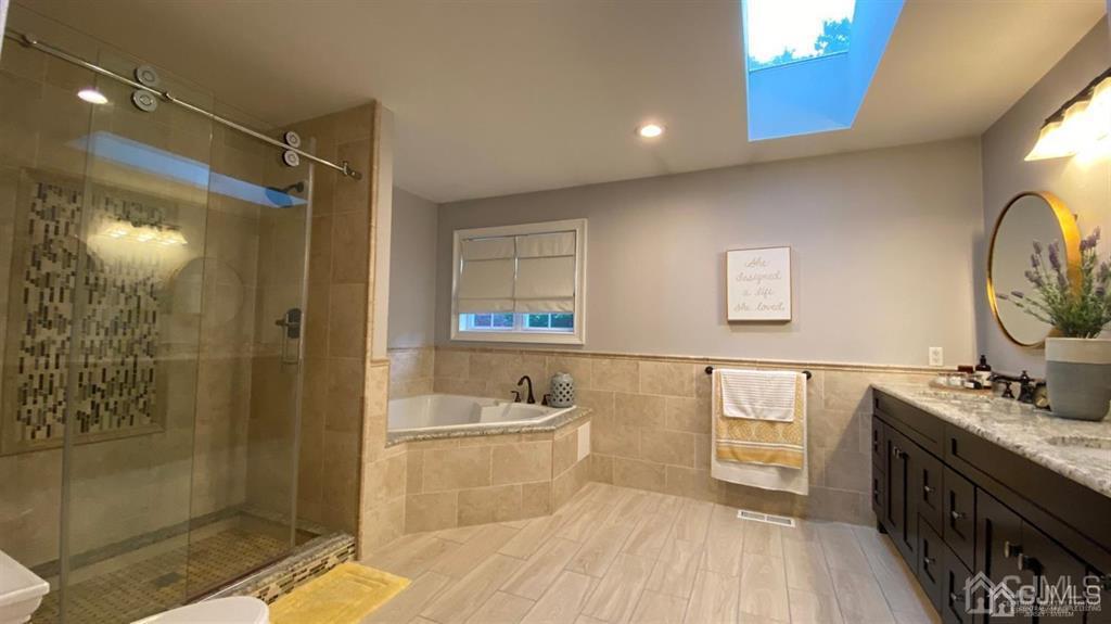 45 Stratton Road Old Bridge, NJ 07747 - Photo 16 of 19 a spacious bathroom with a double vanity sink a mirror and a bathtub
