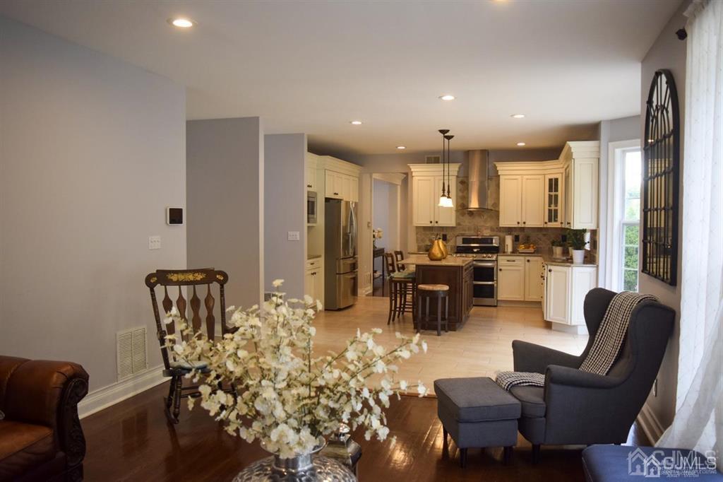 45 Stratton Road Old Bridge, NJ 07747 - Photo 7 of 19 a kitchen with stainless steel appliances granite countertop a refrigerator a stove a dining table and chairs couches with wooden floor