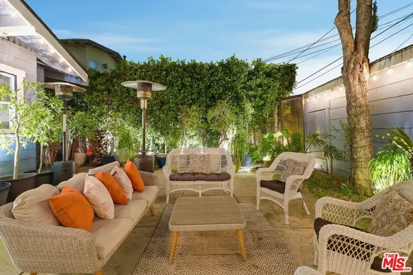 a view of patio with couches table and chairs and potted plants