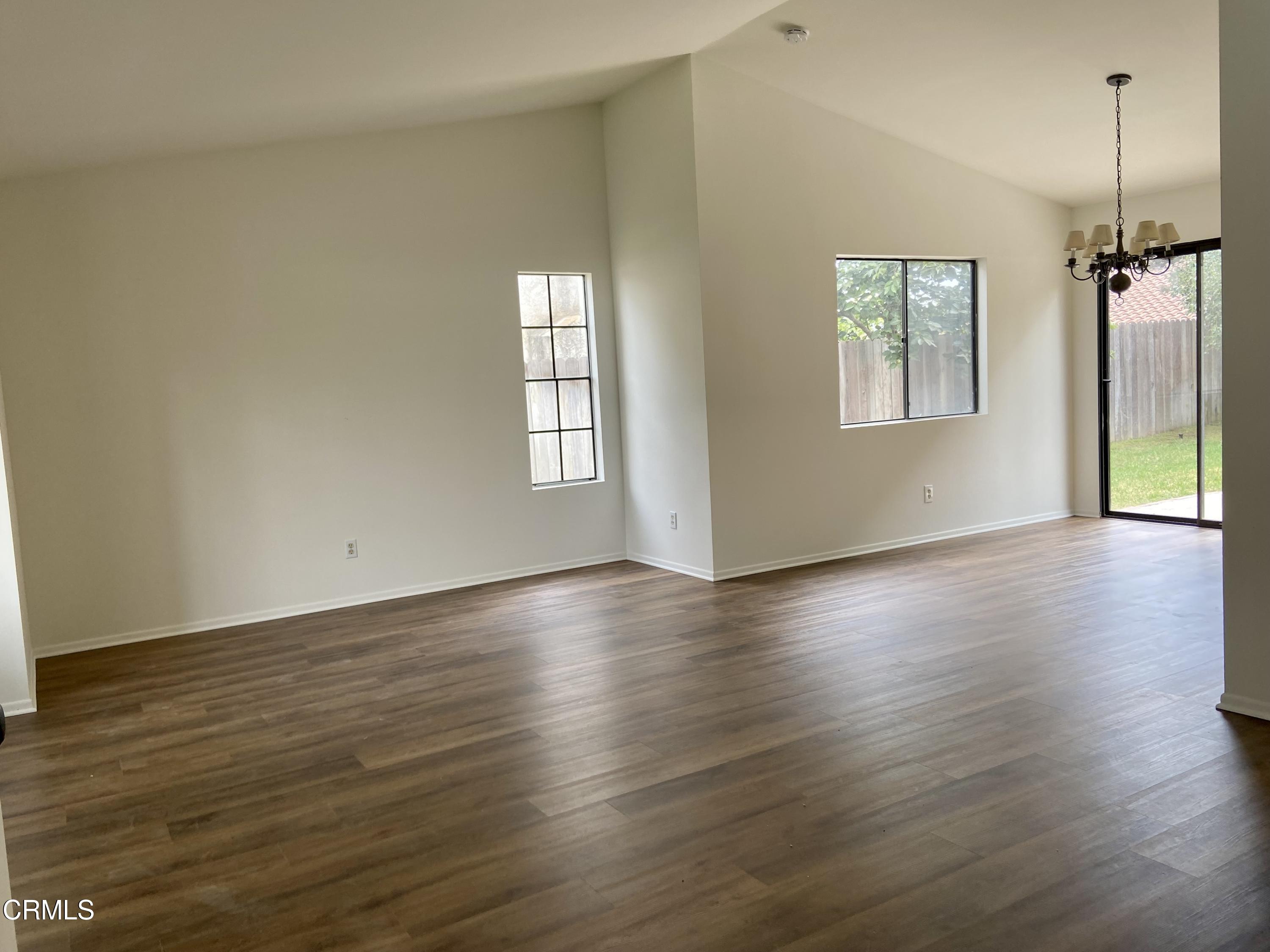 4465 Pine Ridge Court Moorpark, CA 93021 - Photo 3 of 22 an empty room with wooden floor windows and glass door