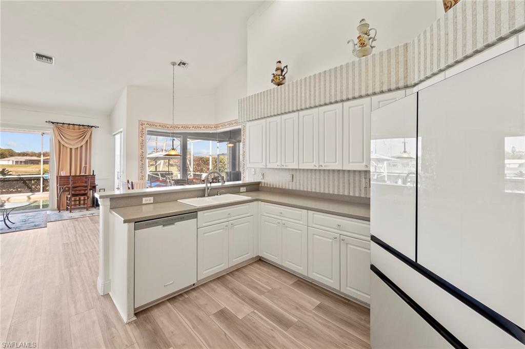 20810 Rivers Ford Estero, FL 33928 - Photo 23 of 49 a kitchen with white cabinets and appliances