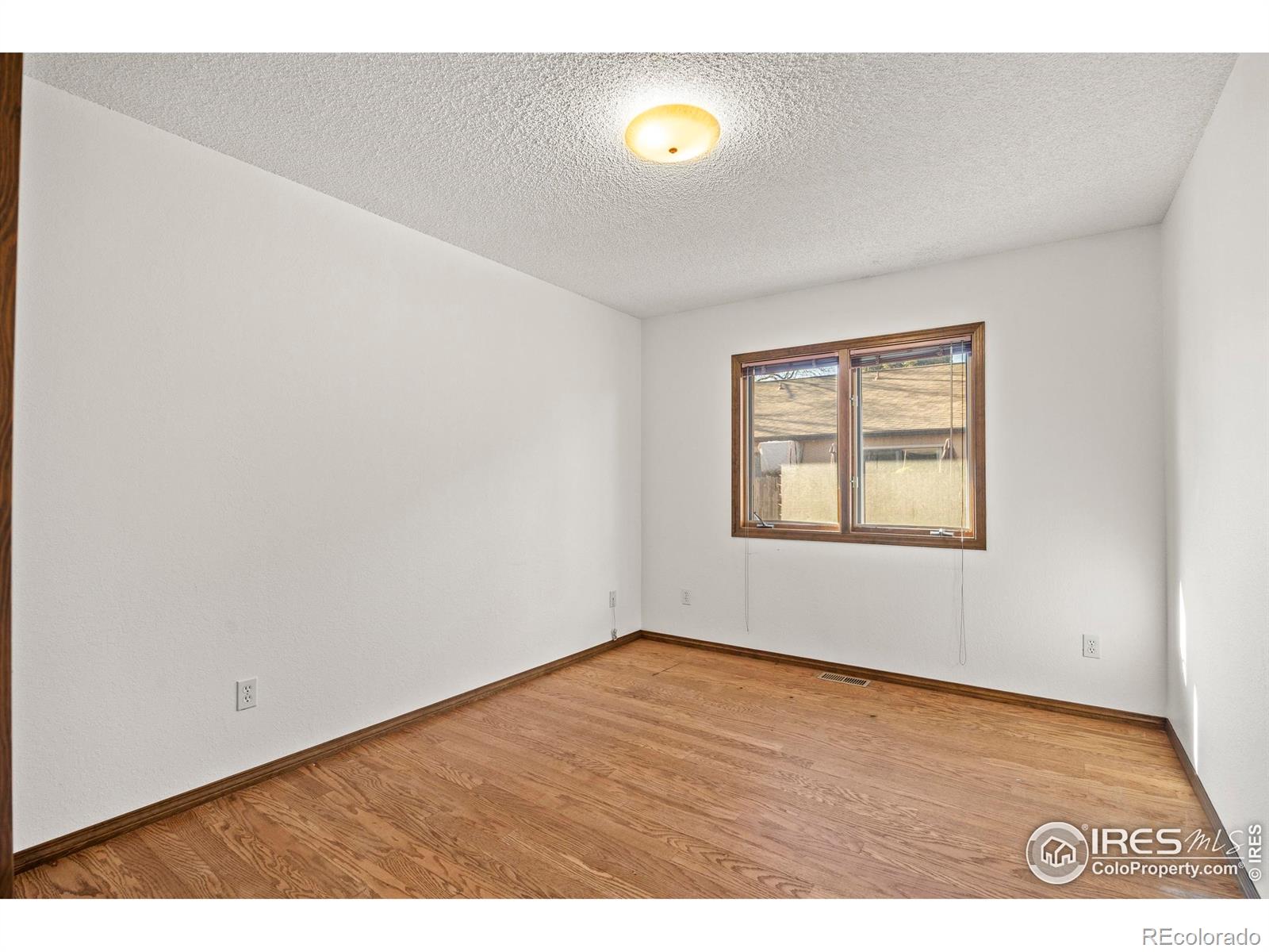 903 Conifer Court Windsor, CO 80550 - Photo 26 of 33 an empty room with wooden floor and windows