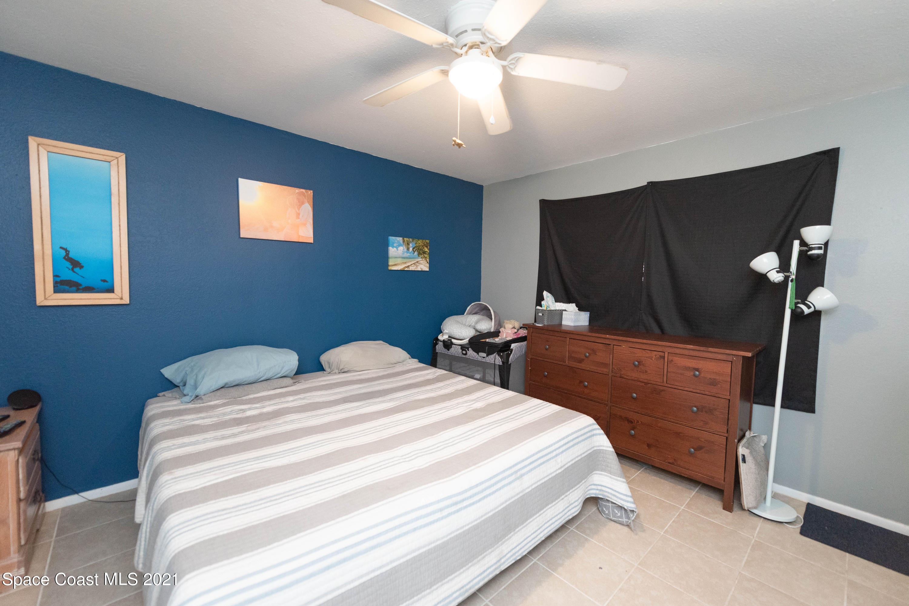 237 Chase Road Cocoa, FL 32927 - Photo 13 of 20 a bedroom with a bed and a chandelier
