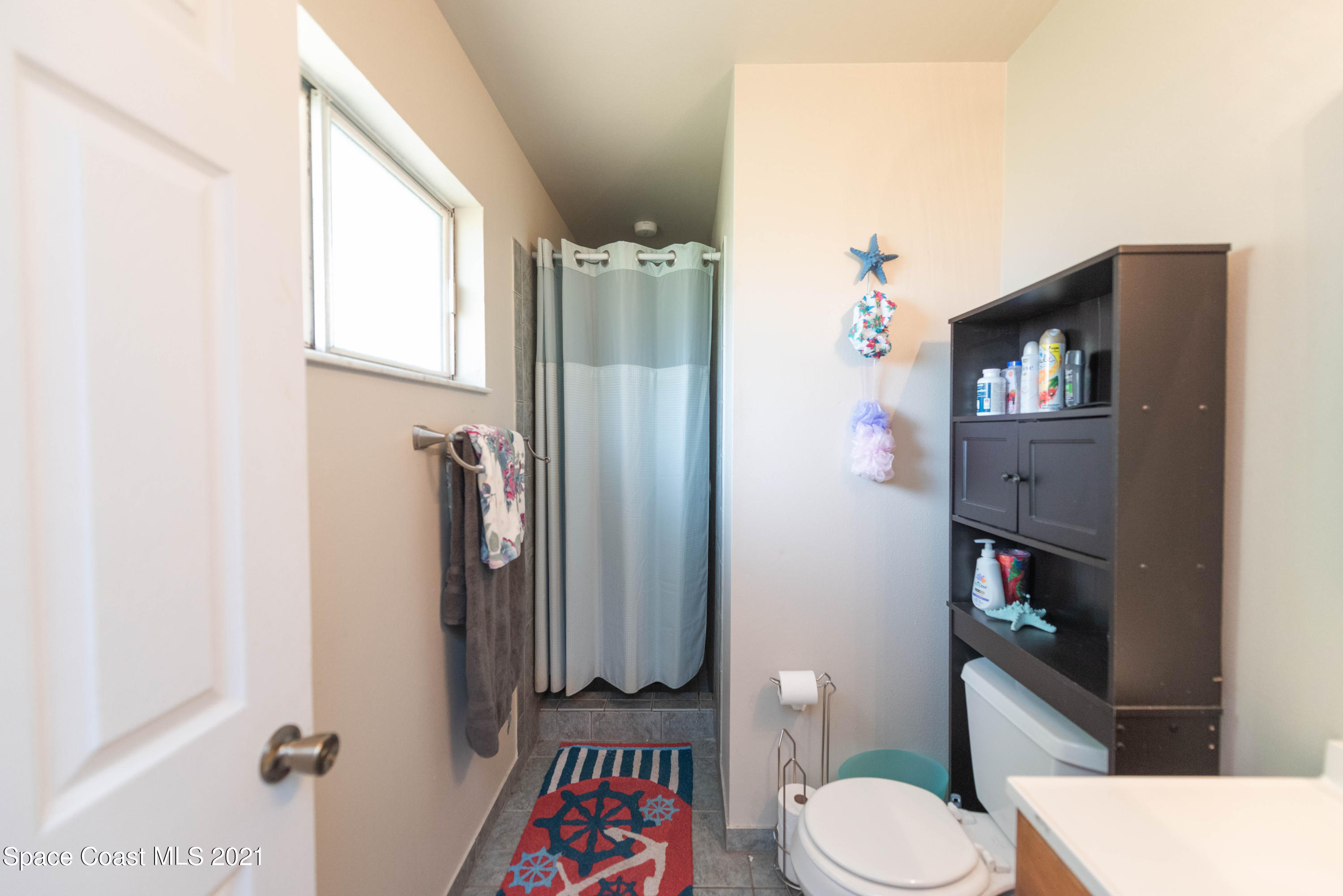 237 Chase Road Cocoa, FL 32927 - Photo 14 of 20 a bathroom with a toilet and a shower curtain