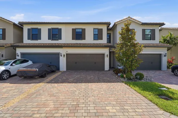 a front view of a house with a yard and a garage