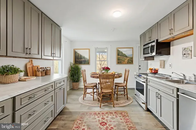 a kitchen with stainless steel appliances kitchen island granite countertop a sink and cabinets