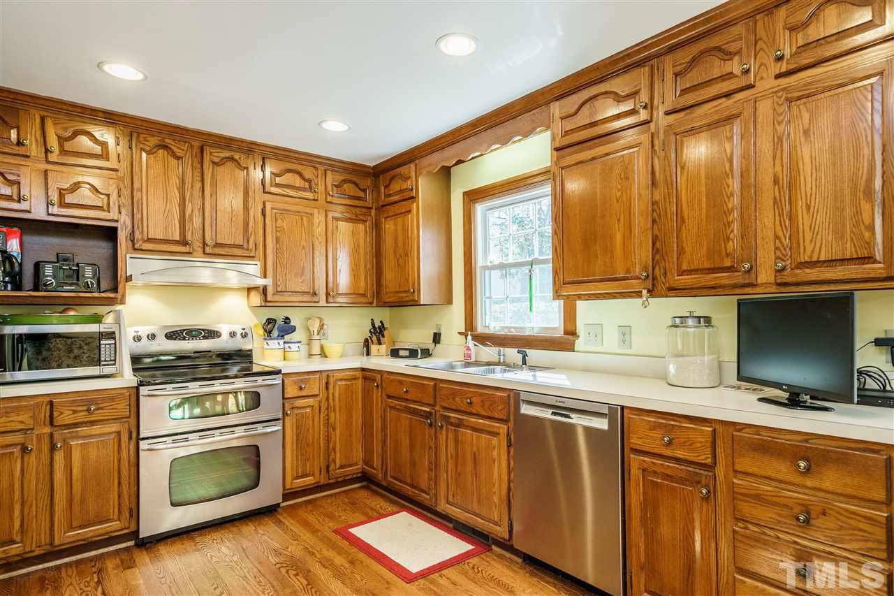 2212 Tyson Street Raleigh, NC 27612 - Photo 10 of 24 a kitchen with stainless steel appliances granite countertop a sink a stove cabinets and wooden floor