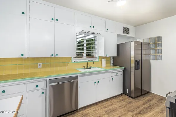 a kitchen with a sink a refrigerator and cabinets