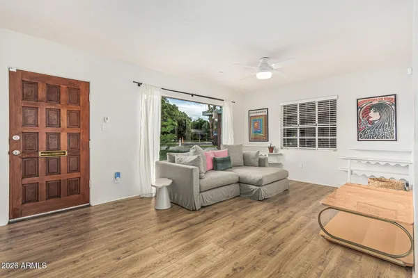 a living room with furniture a large window and wooden floor