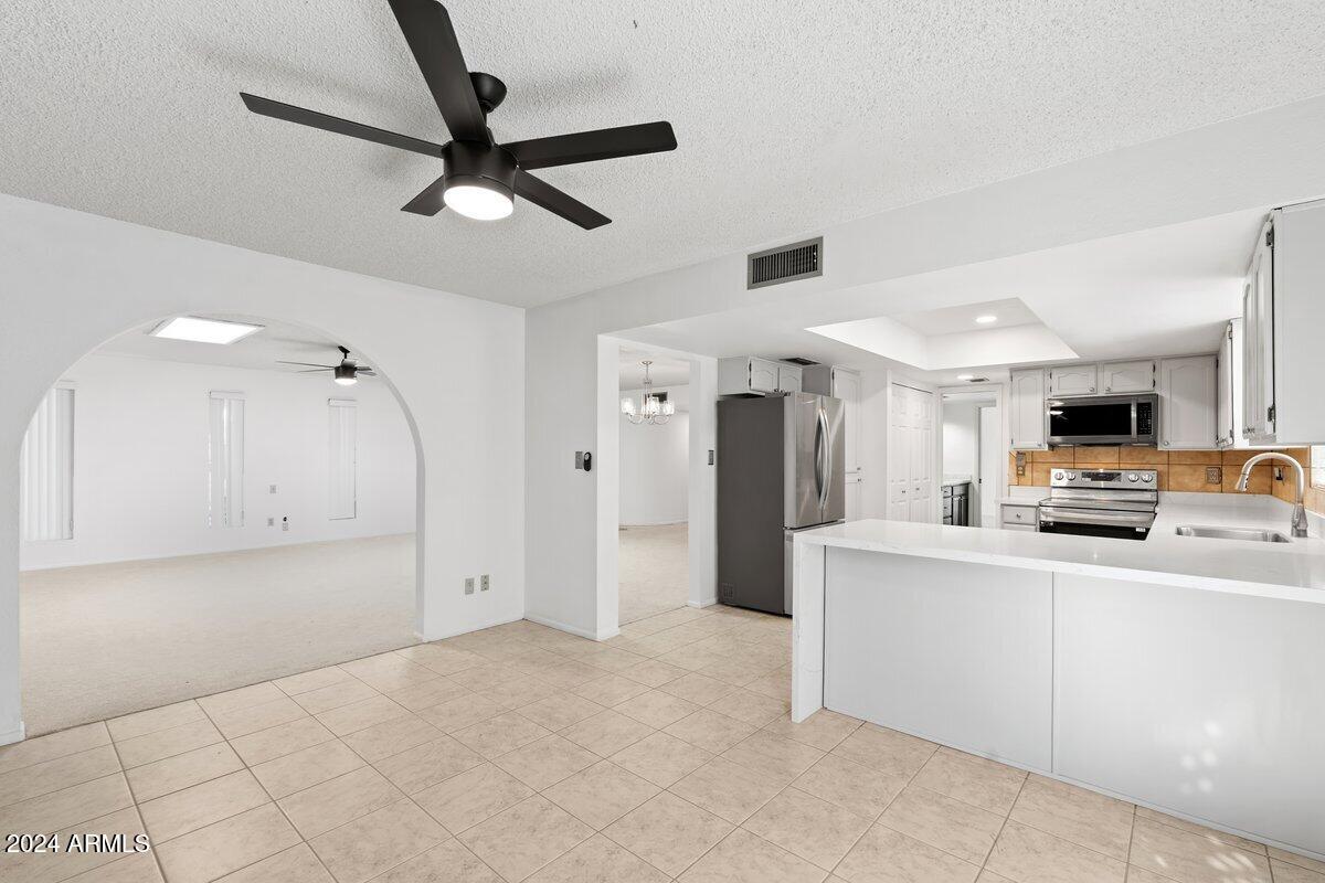6105 North 12th Way Phoenix, AZ 85014 - Photo 12 of 29 a kitchen with kitchen island white cabinets and refrigerator