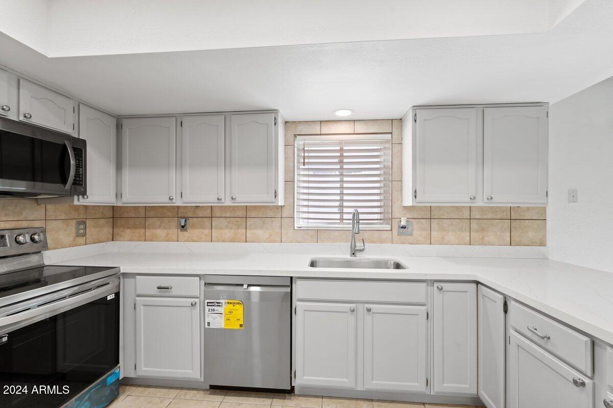 6105 North 12th Way Phoenix, AZ 85014 - Photo 13 of 29 a kitchen with appliances cabinets and a sink