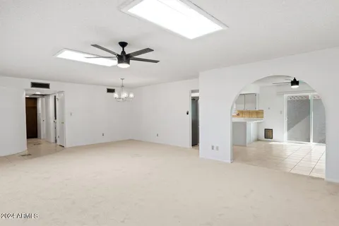 an empty room with windows and ceiling fan