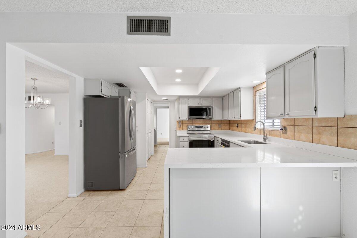 6105 North 12th Way Phoenix, AZ 85014 - Photo 9 of 29 a kitchen with stainless steel appliances a refrigerator sink and microwave