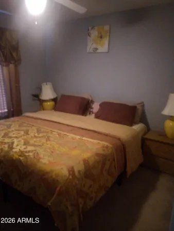 a bedroom with a bed and painting on the wall