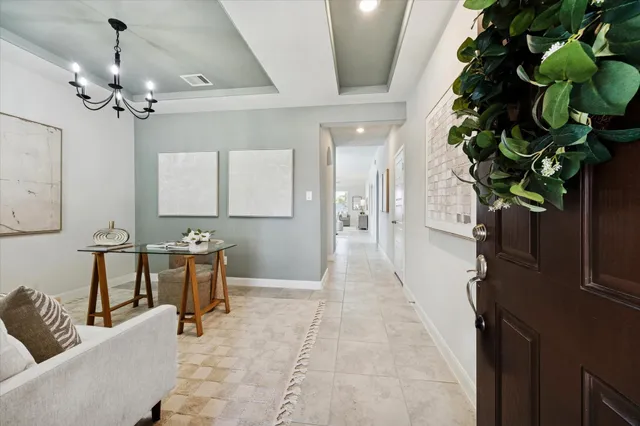 a living room with furniture a chandelier and a potted plant