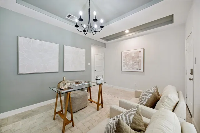 a living room with furniture a dining table and a chandelier