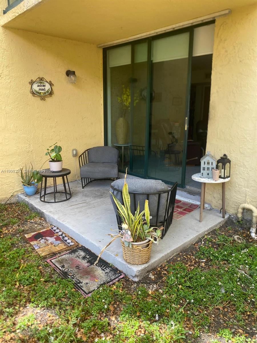 11800 Southwest 18th Street, Unit 1084 Miami, FL 33175 - Photo 28 of 30 a living room with patio furniture and a table