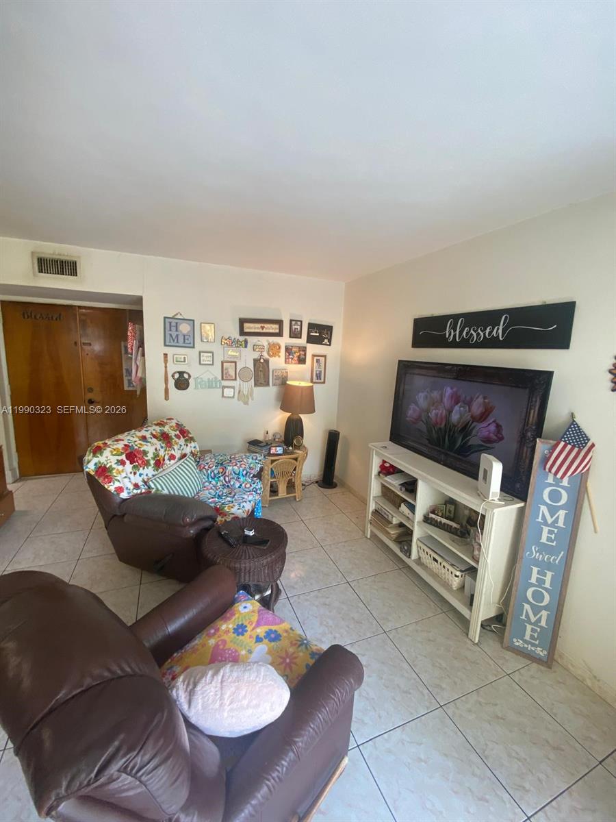 11800 Southwest 18th Street, Unit 1084 Miami, FL 33175 - Photo 9 of 30 a room with furniture and a flat screen tv