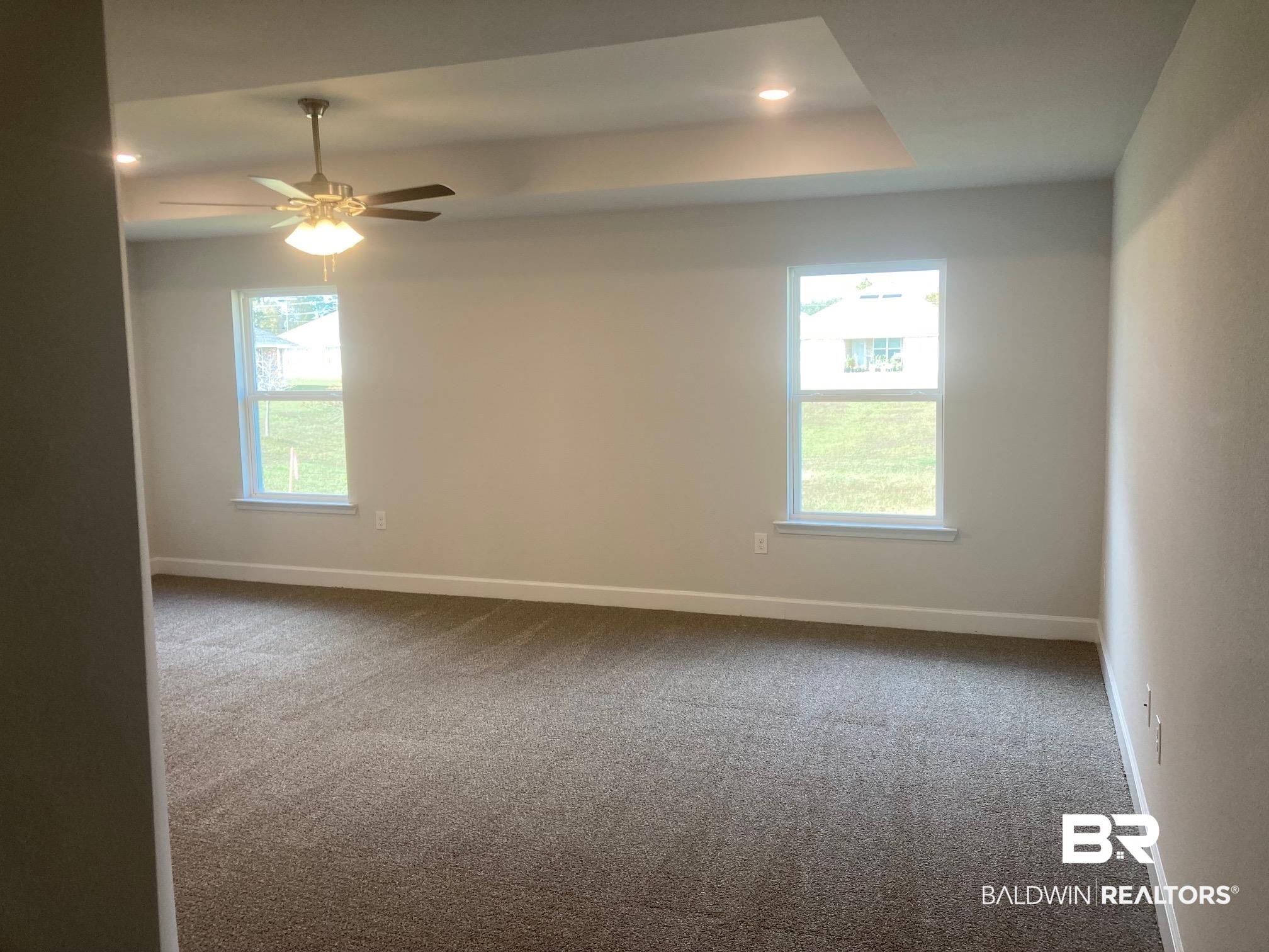 629 Revere Street Foley, AL 36535 - Photo 16 of 30 Unfurnished room with carpet floors, a tray ceiling, and ceiling fan