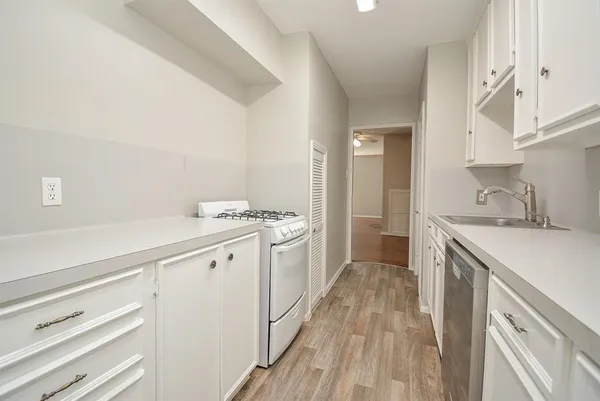 a view of a kitchen with a sink and wooden floor