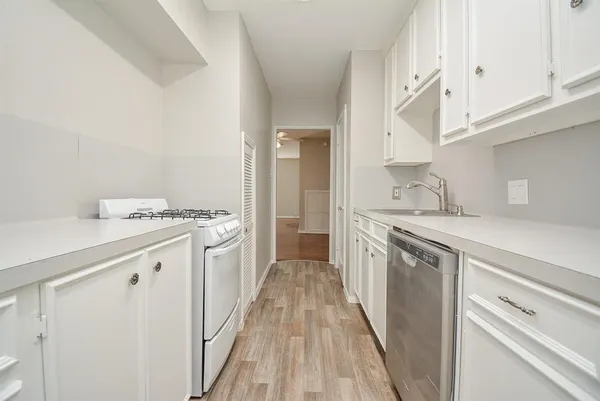 a kitchen with granite countertop a sink stove and refrigerator