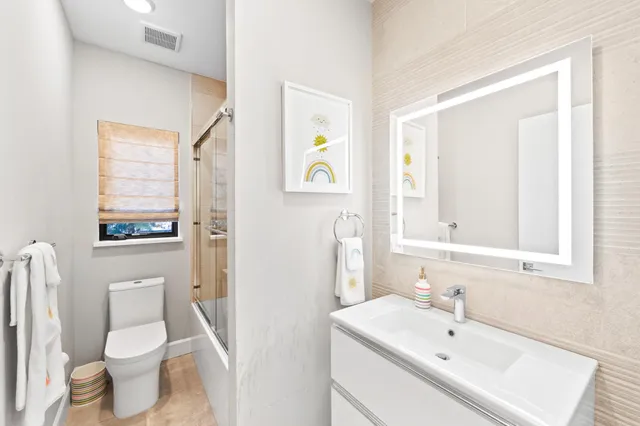 a white toilet sitting next to a bathroom sink