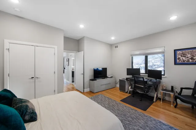 a bedroom with a bed and wooden floor