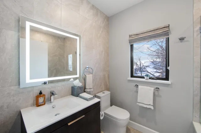 a bathroom with a sink mirror and toilet