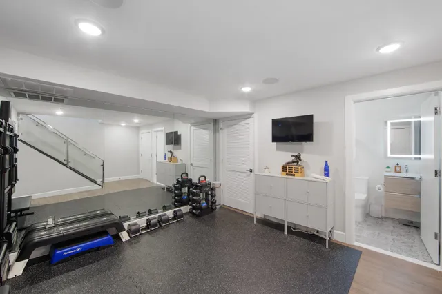 a view of a livingroom with gym equipment and a flat screen tv