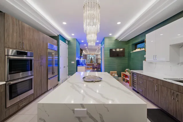a kitchen with stainless steel appliances kitchen island granite countertop a sink and cabinets