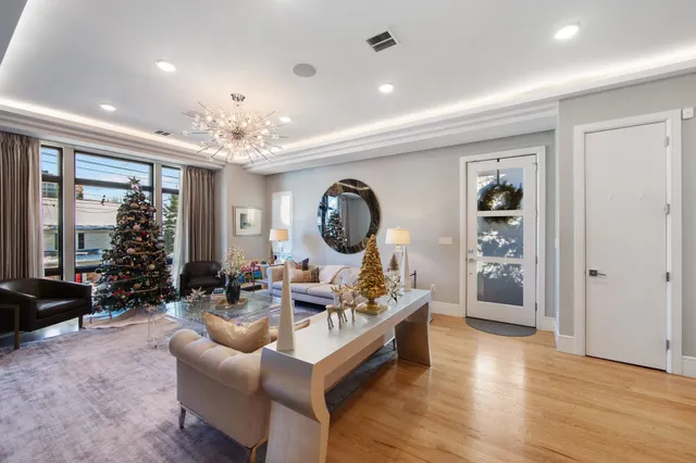 a living room with furniture a large window and a chandelier