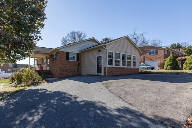 a view of a wooden house with a large tree