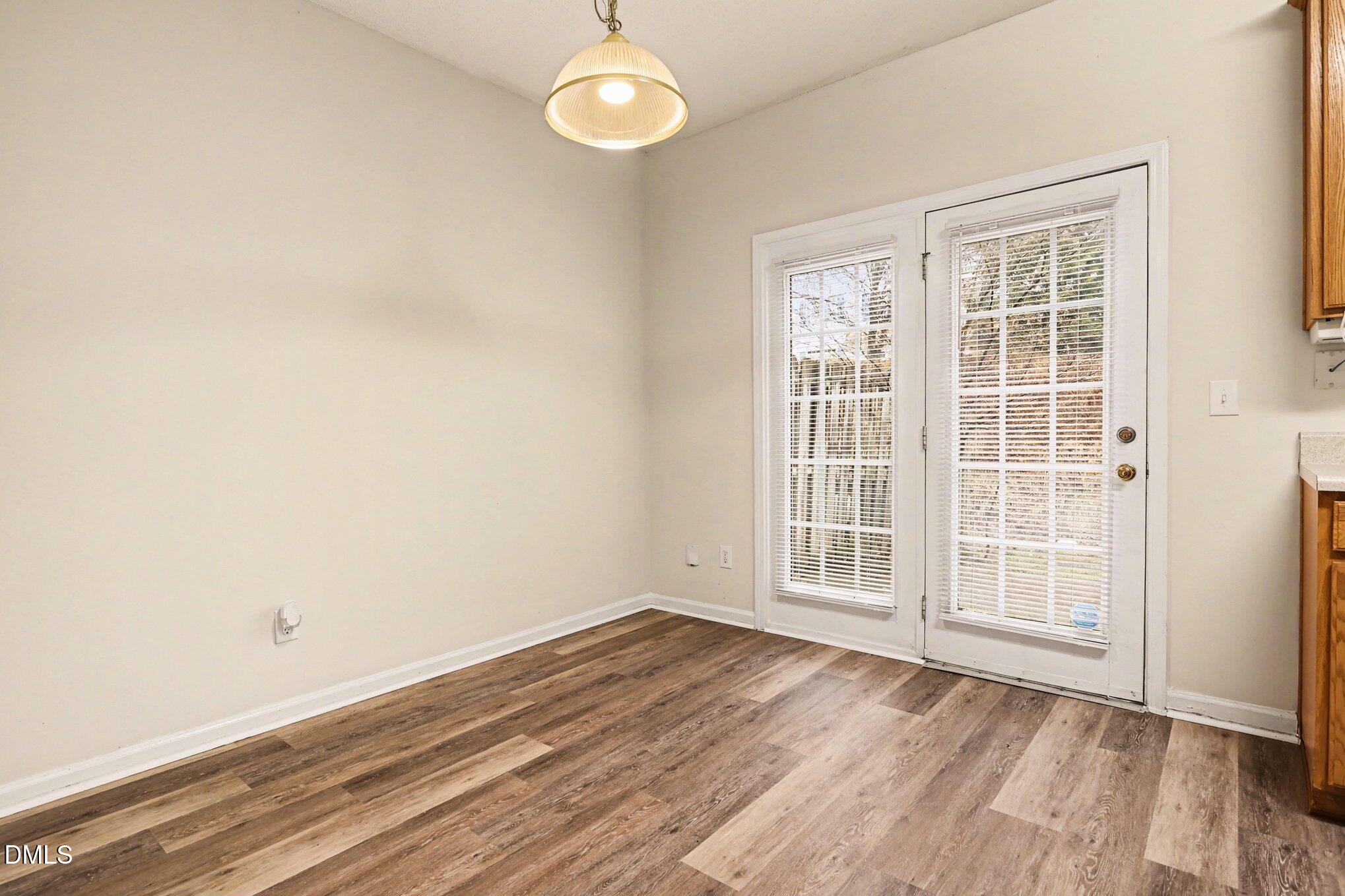 10947 Pendragon Place Raleigh, NC 27614 - Photo 8 of 21 an empty room with wooden floor and windows