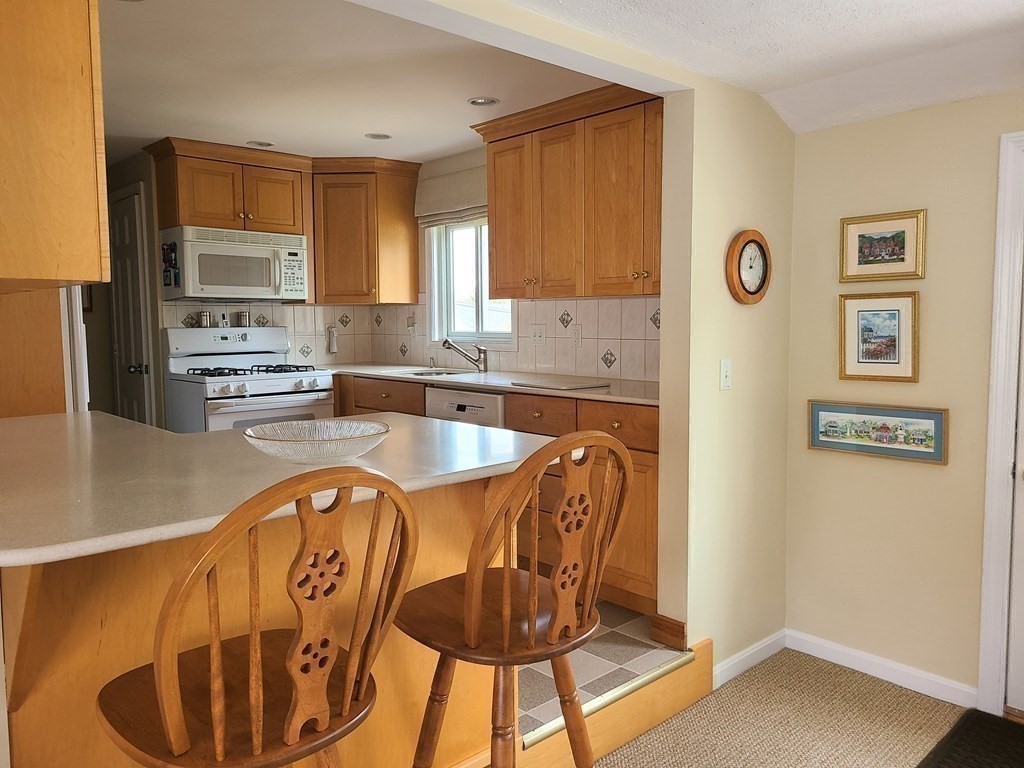 1 Lexington Circle Canton, MA 02021 - Photo 11 of 41 a kitchen with stainless steel appliances granite countertop a dining table chairs and a refrigerator