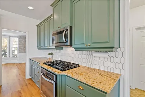 a living room with a baby crib furniture a chandelier and a window