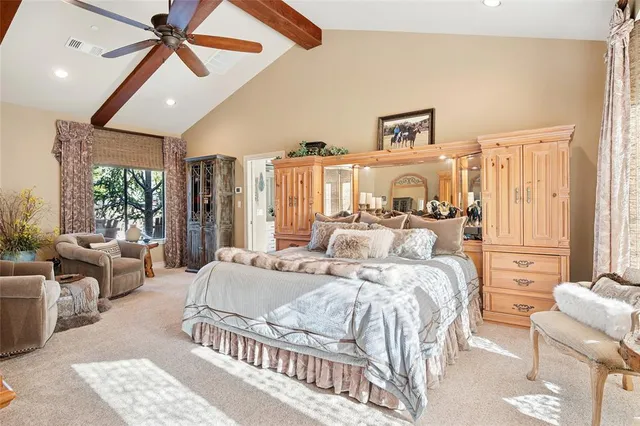 a bedroom with a bed a couch and a chandelier