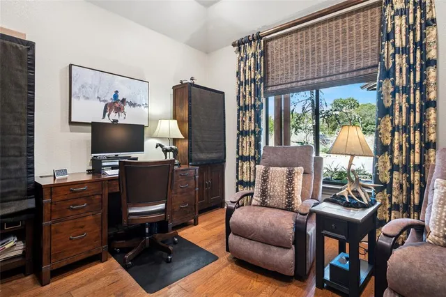 a living room with furniture a flat screen tv and a floor to ceiling window