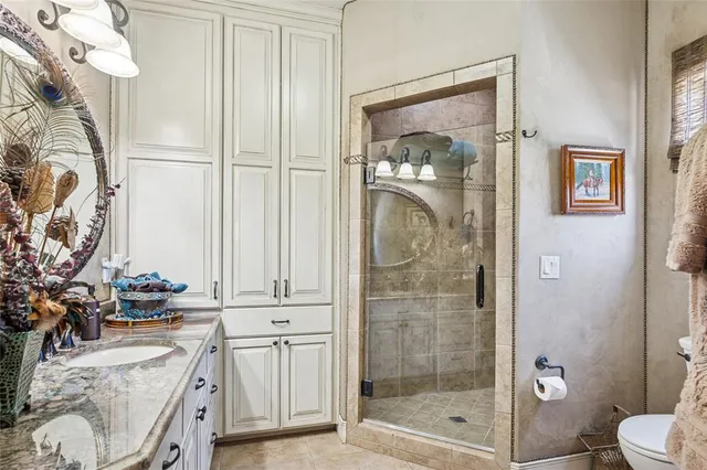 a bathroom with a granite countertop sink a toilet and shower