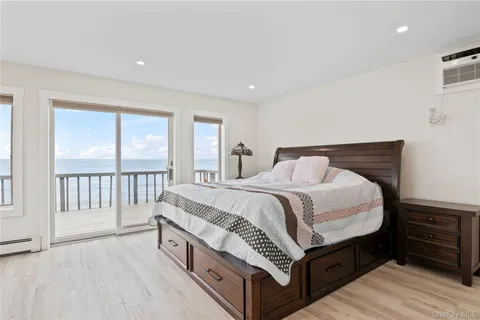 a spacious bedroom with a bed and a dresser next to a window