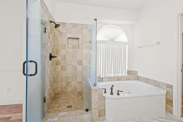 a bathroom with a tub shower and sink