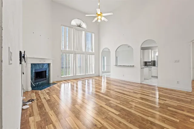 a view of empty room with fireplace and wooden floor