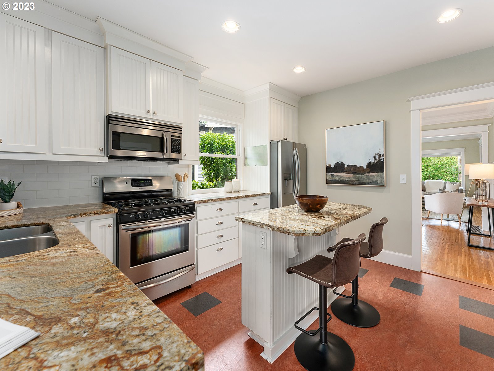 1920 Southeast 47th Avenue Portland, OR 97215 - Photo 13 of 40 a kitchen with stainless steel appliances kitchen island granite countertop a stove a sink a microwave and wooden cabinets